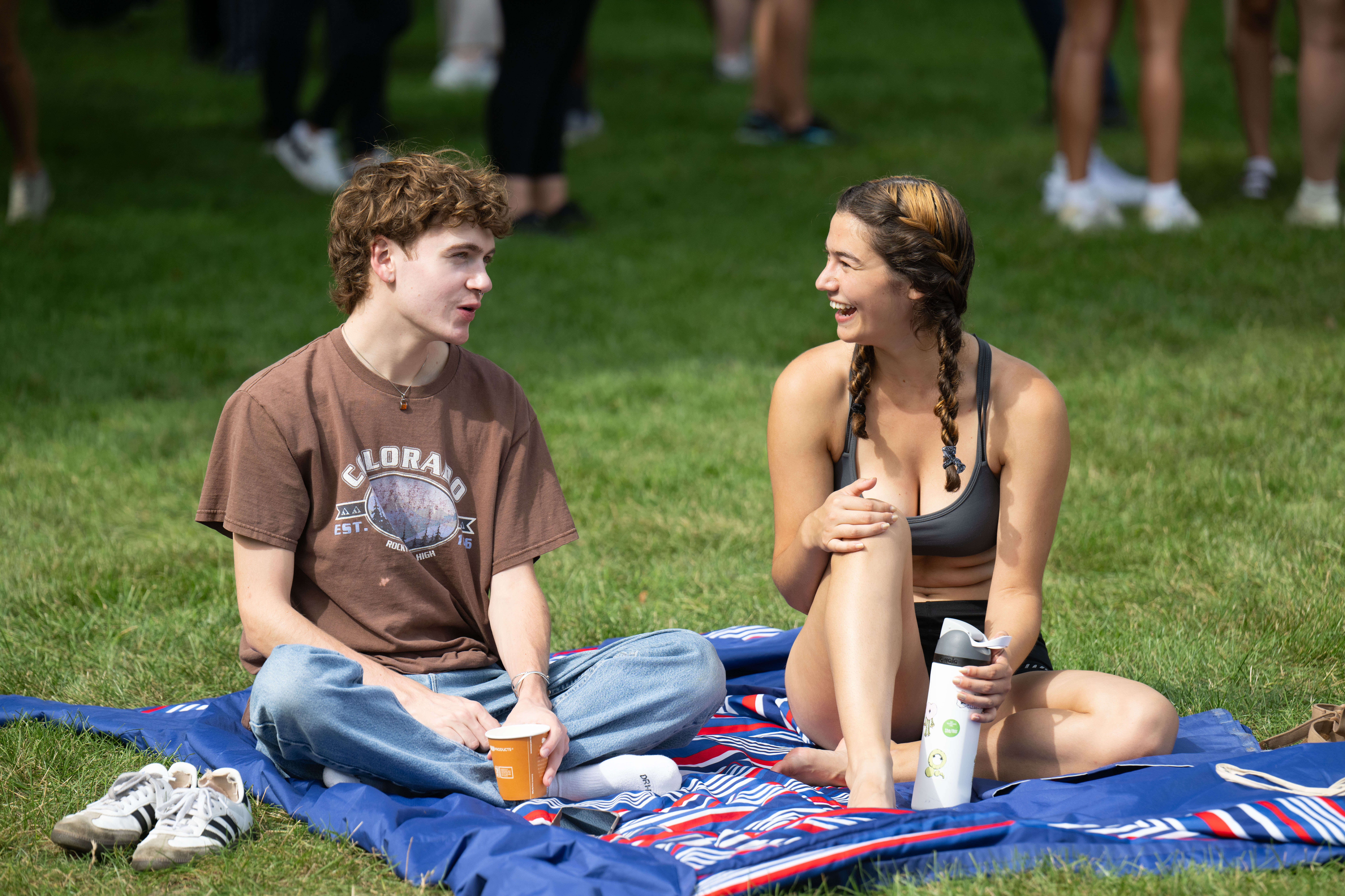 students sitting on a picnic blanket