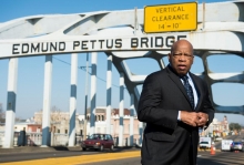 John Lewis against a picture of the Edmund Pettus Bridge in Selma