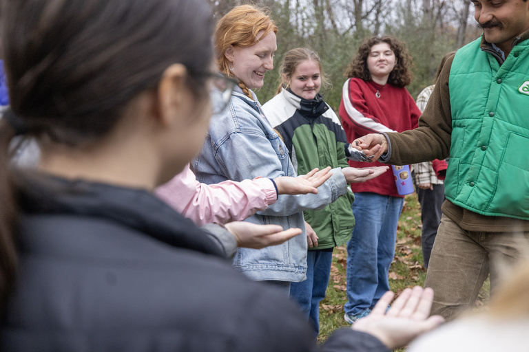 Student holding a songbird at the Iowa Raptor Project