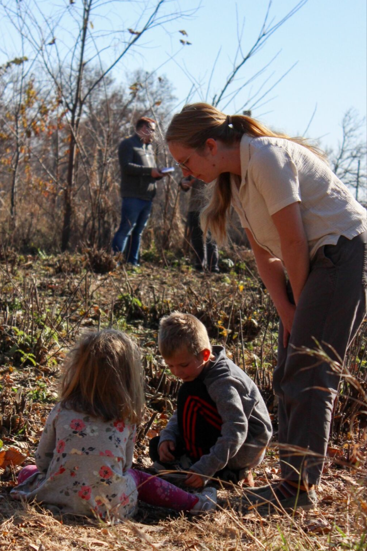 A mother and her two children looking at kozo stumps.