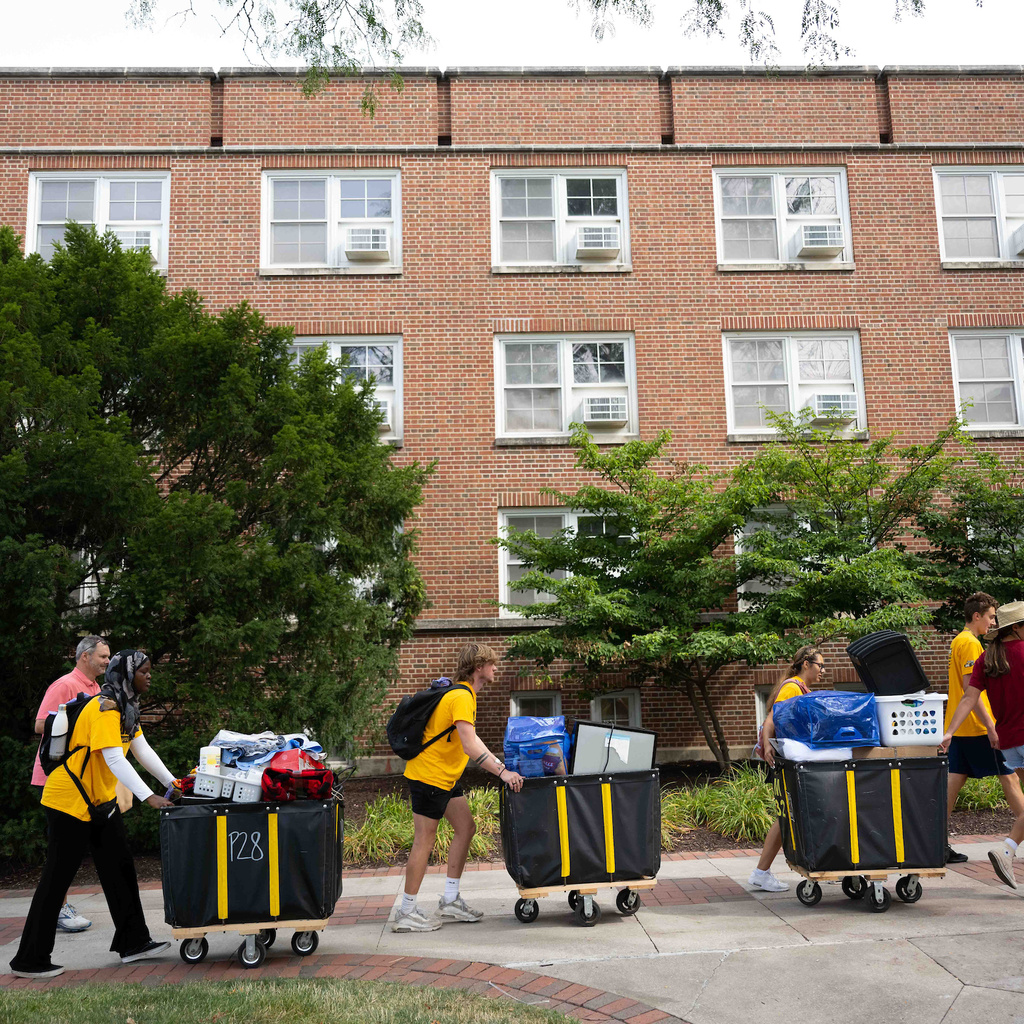 Students pushing carts of household items as they move into their residence hall