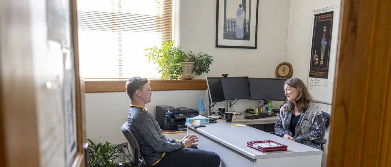 Two people sitting at desk in an office