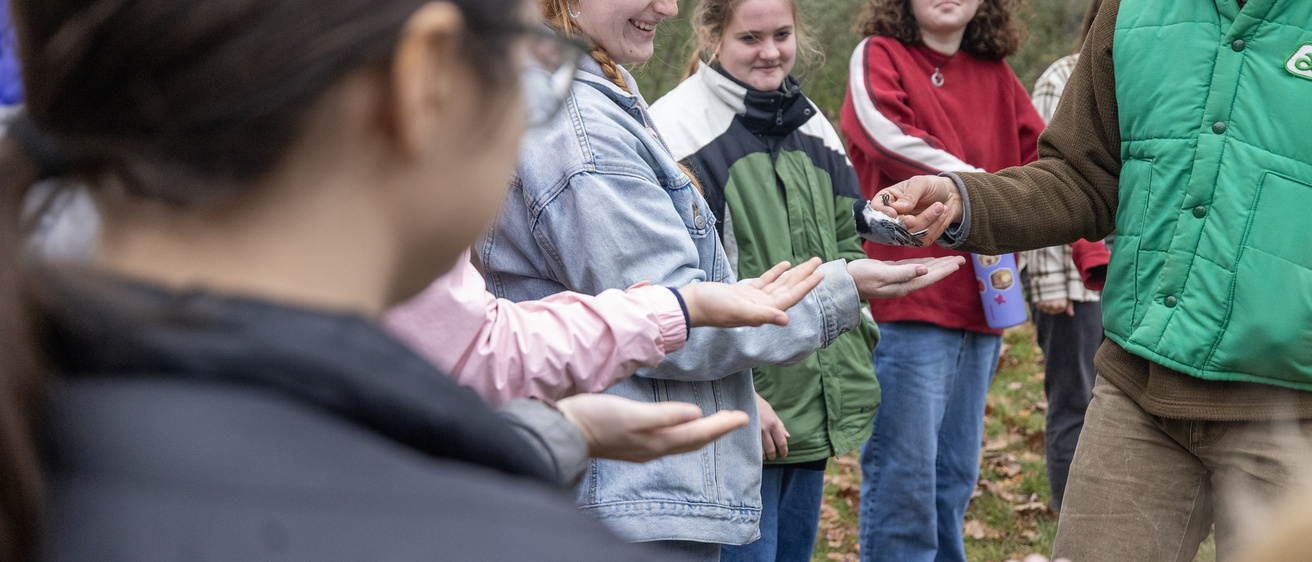 Student holding a songbird at the Iowa Raptor Project