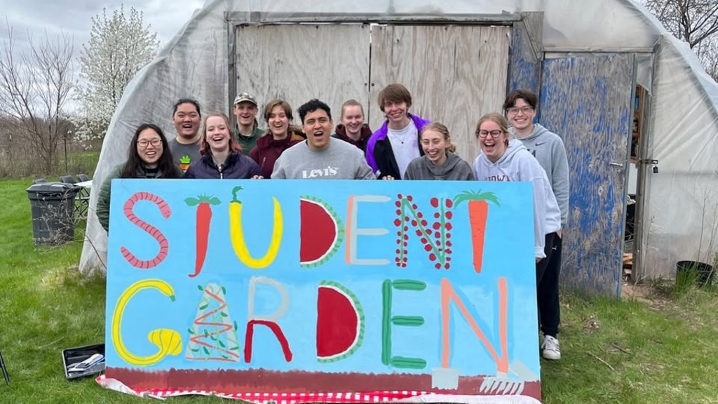 Group photo of students holding a large sign that says "student garden"