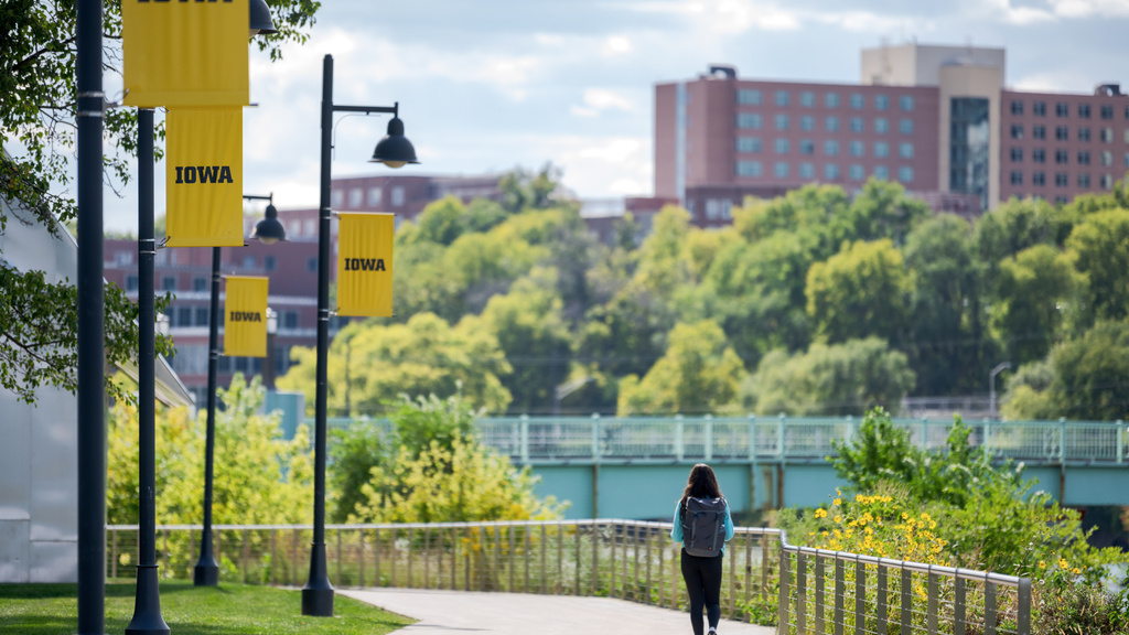 Student Walking by Iowa River